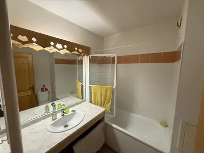 a bathroom with a sink and a mirror and a tub at Appartement cosy 1 chambre - Samoëns - Wifi - FR-1-846-25 in Samoëns