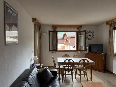 a living room with a couch and a table and chairs at Appartement cosy 1 chambre - Samoëns - Wifi - FR-1-846-25 in Samoëns