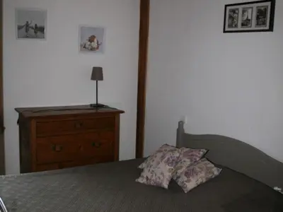 a bedroom with a bed with a dresser and a lamp at Maison conviviale à Samoëns - 2 chambres, Wi-Fi, pour 6 personnes - FR-1-846-29 in Samoëns