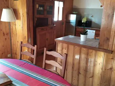 a kitchen with a counter and a table and chairs at Maison conviviale à Samoëns - 2 chambres, Wi-Fi, pour 6 personnes - FR-1-846-29 in Samoëns