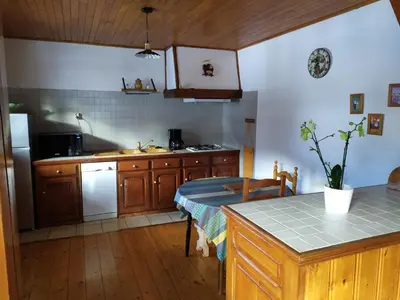 a kitchen with wooden cabinets and a counter top at Maison conviviale à Samoëns - 2 chambres, Wi-Fi, pour 6 personnes - FR-1-846-29 in Samoëns