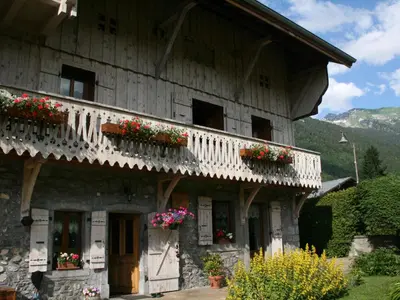 a building with flower boxes on the side of it at Maison conviviale à Samoëns - 2 chambres, Wi-Fi, pour 6 personnes - FR-1-846-29 in Samoëns