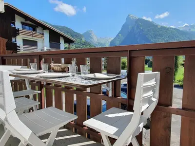 a wooden deck with a table and chairs on it at Appartement 4 pers. 1 ch. avec lave-linge à Samoëns - FR-1-846-37 in Samoëns