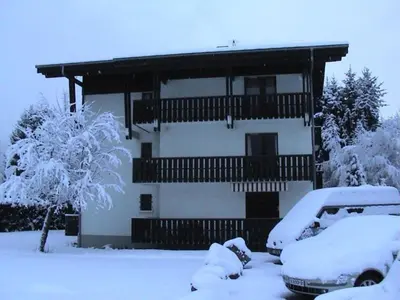 a snow covered house with cars parked in front of it at Appartement 4 pers. 1 ch. avec lave-linge à Samoëns - FR-1-846-37 in Samoëns
