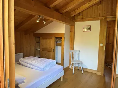 a small bedroom with a bed and a chair at Chalet pour 8 avec Wifi à Samoëns - FR-1-846-36 in Samoëns