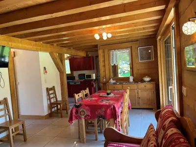 a dining room with a table and a kitchen at Chalet pour 8 avec Wifi à Samoëns - FR-1-846-36 in Samoëns