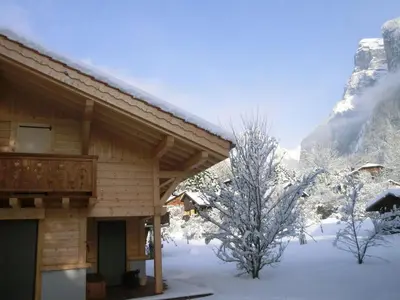 a log cabin in the snow with trees and mountains at Chalet pour 8 avec Wifi à Samoëns - FR-1-846-36 in Samoëns