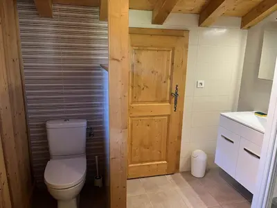 a bathroom with a toilet and a wooden door at Chalet pour 8 avec Wifi à Samoëns - FR-1-846-36 in Samoëns
