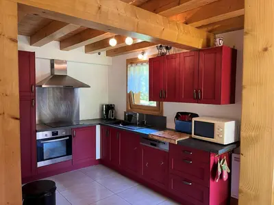 a kitchen with red cabinets and a microwave at Chalet pour 8 avec Wifi à Samoëns - FR-1-846-36 in Samoëns