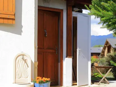 an open door of a house with a flower pot at Charmante Villa à Samoëns avec Wifi et 2 Chambres - FR-1-846-34 in Samoëns