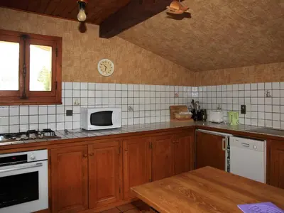 a kitchen with wooden cabinets and a white microwave at Charmante Villa à Samoëns avec Wifi et 2 Chambres - FR-1-846-34 in Samoëns