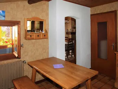 a room with a wooden table and a dining room at Charmante Villa à Samoëns avec Wifi et 2 Chambres - FR-1-846-34 in Samoëns