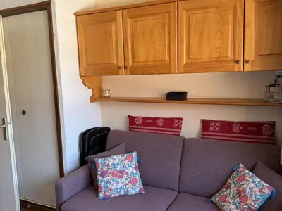a living room with a couch and wooden cabinets at Studio Samoëns - 4 pers, cosy & pratique - FR-1-846-33 in Samoëns