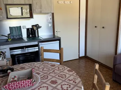 a kitchen with a table and a kitchen with a stove at Studio Samoëns - 4 pers, cosy & pratique - FR-1-846-33 in Samoëns