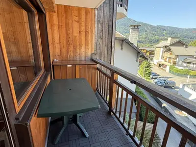 a balcony with a green bench on a wooden railing at Studio Samoëns - 4 pers, cosy & pratique - FR-1-846-33 in Samoëns