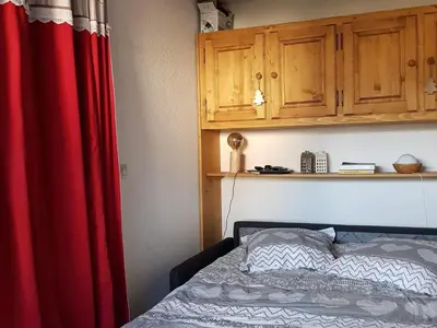 a bedroom with a red curtain and a bed at Charmant appartement avec Wifi à Samoëns - FR-1-846-35 in Samoëns
