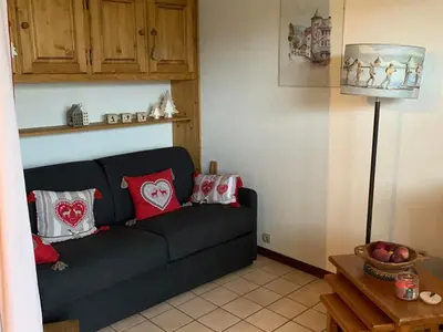 a living room with a black couch with red pillows at Charmant appartement avec Wifi à Samoëns - FR-1-846-35 in Samoëns