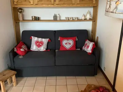 a black couch with red and white pillows on it at Charmant appartement avec Wifi à Samoëns - FR-1-846-35 in Samoëns