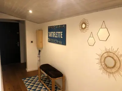 a room with a chair and a mirror on the wall at Appartement Phoebe, Chamonix Centre in Chamonix-Mont-Blanc
