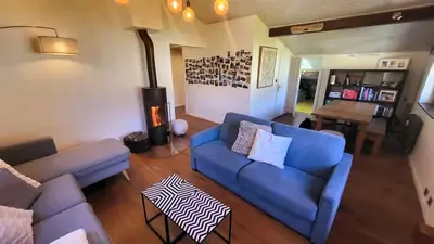 a living room with a blue couch and a fireplace at Appartement Phoebe, Chamonix Centre in Chamonix-Mont-Blanc