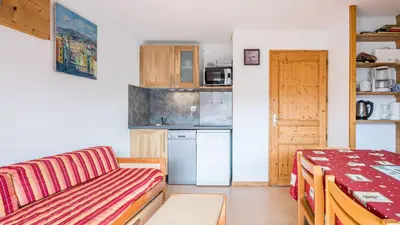 a living room with a couch and a kitchen at Les Eterlous N24 2P6 in Morillon