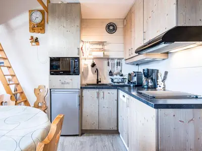 a kitchen with wooden cabinets and a counter top at Grand Horizon 1 N403 2P8 in Morillon