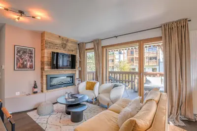 a living room with a couch and a tv at Appartement Prariand - Welkeys in Megève