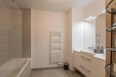 a bathroom with a tub and a sink and a shower at Appartement Prariand - Welkeys in Megève