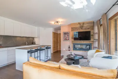 a kitchen and living room with a couch and a table at Appartement Prariand - Welkeys in Megève