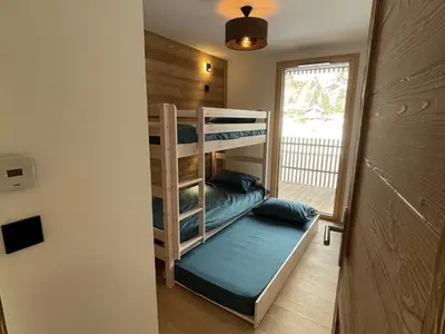 a bunk bed room with two bunk beds and a window at Appartement de standing 3 chambres au centre, pied de piste, parking et WIFI - FR-1-836-5 in Arâches-la-Frasse