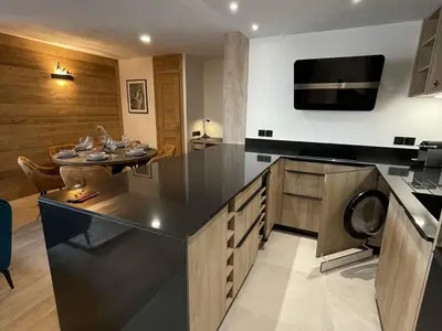 a kitchen with a black counter top and a table at Appartement de standing 3 chambres au centre, pied de piste, parking et WIFI - FR-1-836-5 in Arâches-la-Frasse