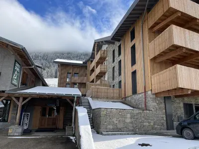 a building with snow on the ground in front of it at Appartement de standing 3 chambres au centre, pied de piste, parking et WIFI - FR-1-836-5 in Arâches-la-Frasse