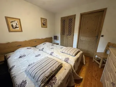 a bedroom with two beds and a wooden floor at Appartement de standing 6 pers avec piscine et parking - FR-1-836-3 in Arâches-la-Frasse