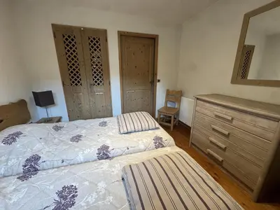 a bedroom with a bed with a dresser and a mirror at Appartement de standing 6 pers avec piscine et parking - FR-1-836-3 in Arâches-la-Frasse
