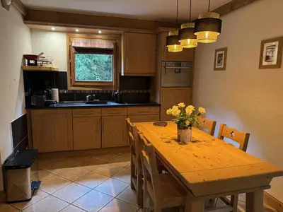 a kitchen with a wooden table with flowers on it at Appartement de standing 6 pers avec piscine et parking - FR-1-836-3 in Arâches-la-Frasse