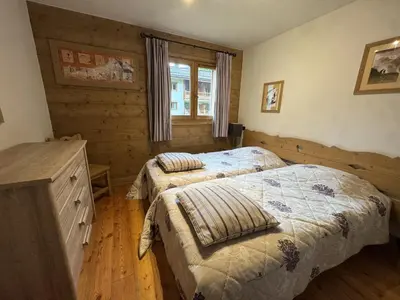 a bedroom with two beds and a dresser and a window at Appartement de standing 6 pers avec piscine et parking - FR-1-836-3 in Arâches-la-Frasse