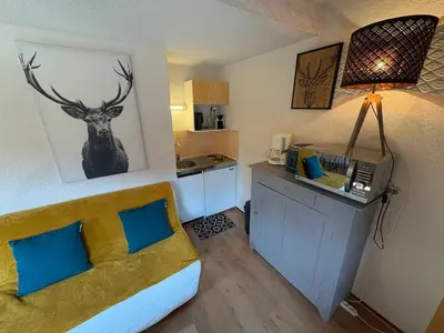 a room with a bed and a kitchen with a deer on the wall at Studio avec mezzanine, balcon et parking privé - Animaux acceptés - FR-1-836-9 in Arâches-la-Frasse