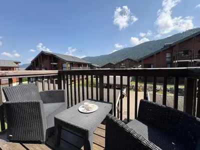 a patio with a table and chairs on a deck at Studio avec mezzanine, balcon et parking privé - Animaux acceptés - FR-1-836-9 in Arâches-la-Frasse