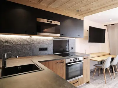 a kitchen with black cabinets and a counter top at Appartement central 1 chambre, 4 pers, WIFI, garage - FR-1-836-12 in Arâches-la-Frasse