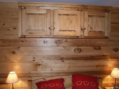 a room with a wooden wall with cabinets and red pillows at Appartement rénové 50 m², 2 chambres, centre, WIFI - FR-1-836-6 in Arâches-la-Frasse