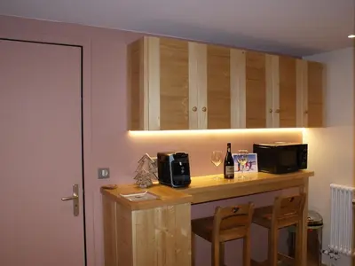 a kitchen with a bar with two chairs and a microwave at Appartement rénové 50 m², 2 chambres, centre, WIFI - FR-1-836-6 in Arâches-la-Frasse