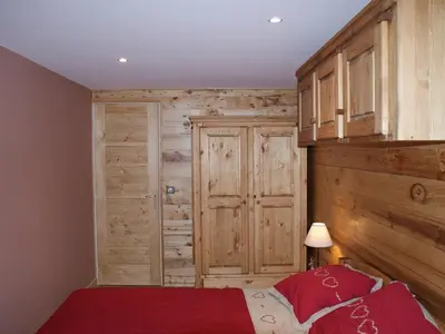 a bedroom with a wood paneled wall and a bed at Appartement rénové 50 m², 2 chambres, centre, WIFI - FR-1-836-6 in Arâches-la-Frasse