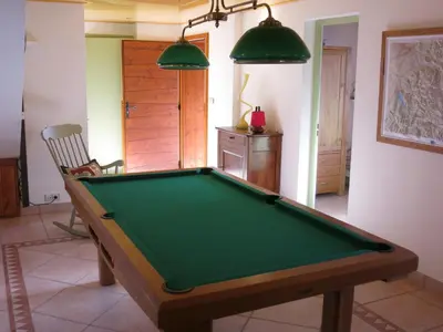 a pool table in a living room with avertisement for at Appartement 2 chambres pour 5 pers avec billard et parking - FR-1-836-11 in Arâches-la-Frasse