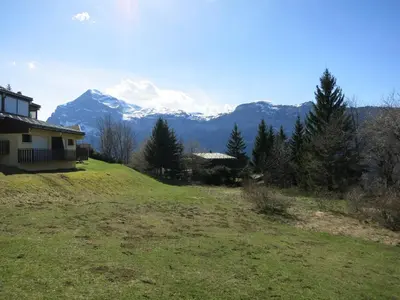 a house on a hill with mountains in the background at Appartement 2 chambres pour 5 pers avec billard et parking - FR-1-836-11 in Arâches-la-Frasse