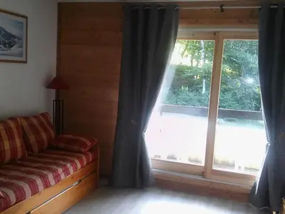 a living room with a couch and a large window at Studio 26 m² - 4 pers - Les Carroz d'Arâches - FR-1-836-10 in Arâches-la-Frasse