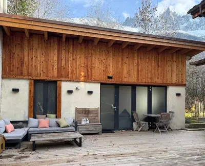 a house with a patio with a couch and a table at Comfortable house - 4 people - quiet in Chamonix-Mont-Blanc