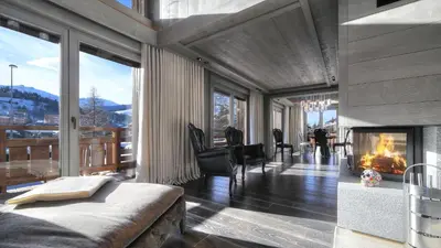 a bedroom with a fireplace and a view of the mountains at Chalet Crystal in Megève