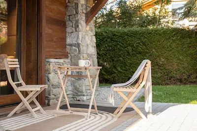 two chairs and a table on a porch at Chalet Crystal in Megève