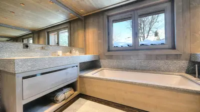a large bathroom with a tub and a window at Chalet Crystal in Megève