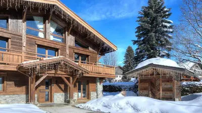 a log home with snow on the ground at Chalet Crystal in Megève